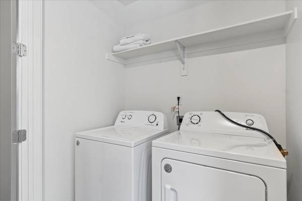 Two white front loading washing machines in a small laundry room. at Paperbox Lofts Apartments, Salt Lake City  , Utah